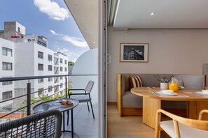 A balcony with a table set for two, a sofa, and a chair. - TOO Colonia Studio Trendy Studio (Mexico City)