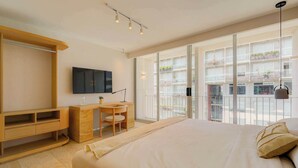 Una camera da letto moderna con un letto grande, una scrivania e un televisore.