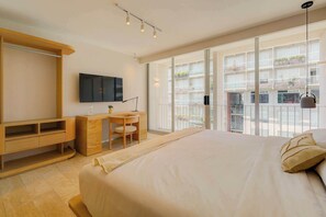 Ein modernes Schlafzimmer mit einem großen Bett, einem Schreibtisch und einem Fernseher.