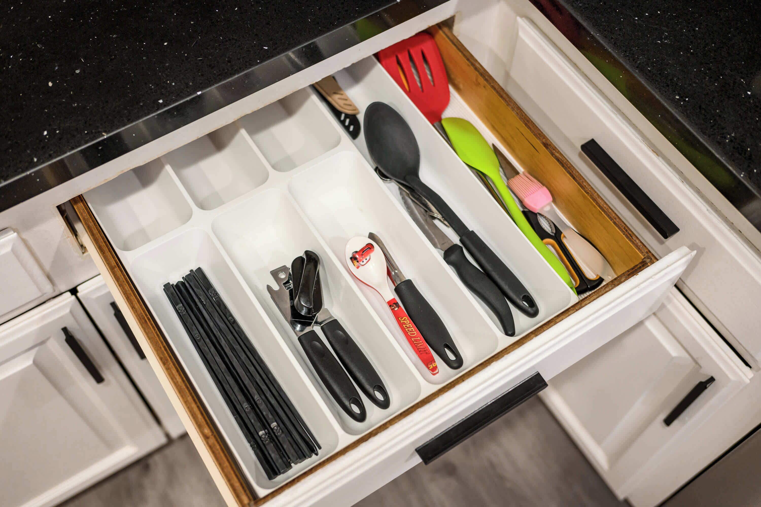 Un cassetto della cucina con diversi utensili e strumenti.