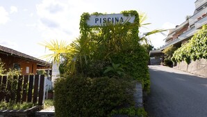 Kyltti, jossa lukee ”PISCINA”, oli sijoitettu vehreän kasvillisuuden ja kivimuurin ympäröimään paikkaan.