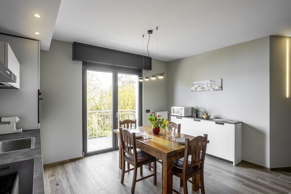 Eine moderne Küche mit Essbereich, großen Fenstern und Blick ins Freie.