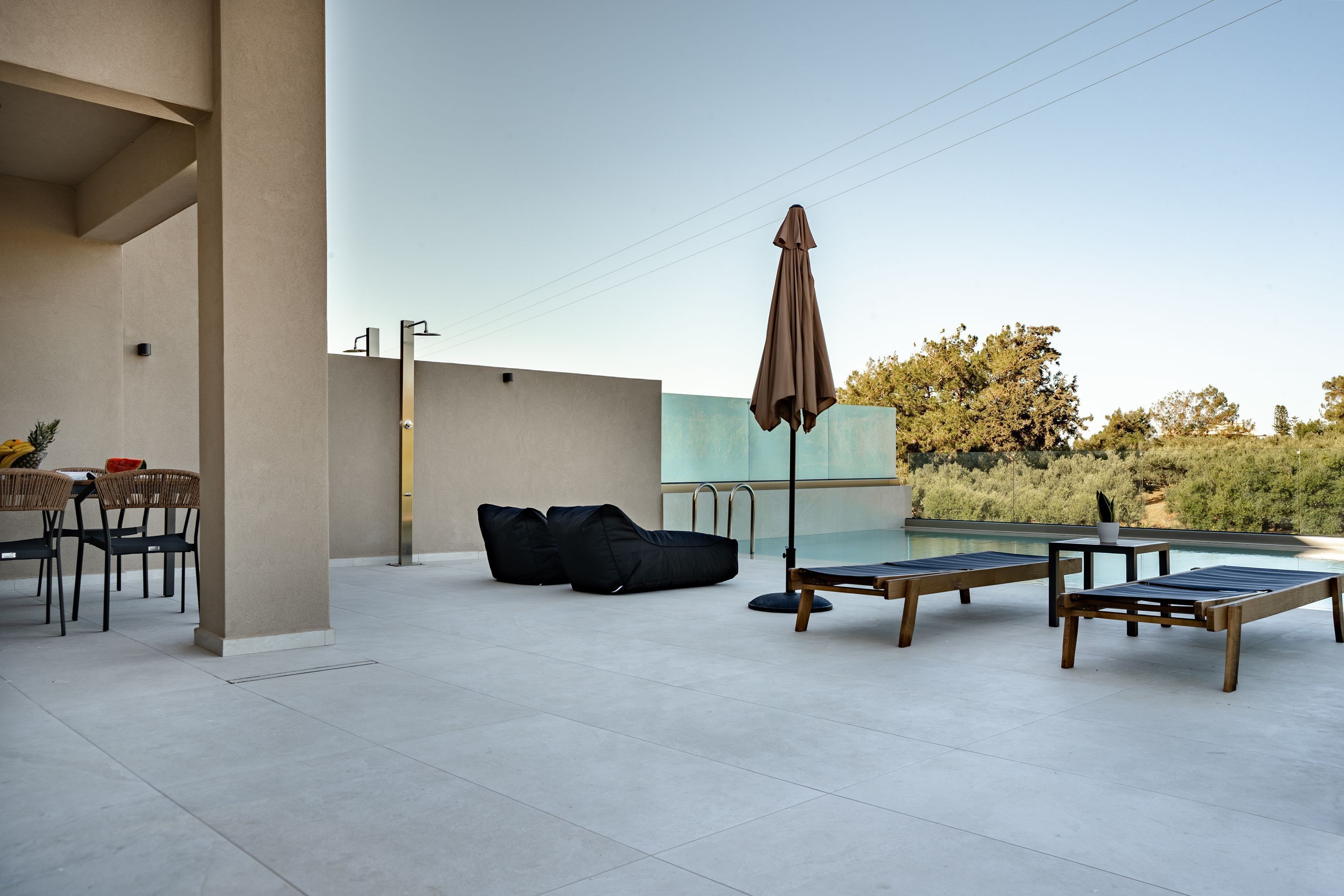 An outdoor patio with a pool, lounge chairs, and a dining area with chairs and a table.