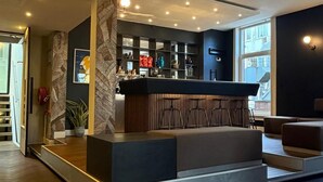 Ett modernt receptionsområde med en receptionsdisk, sittplatser och en vägg med ett mönster.