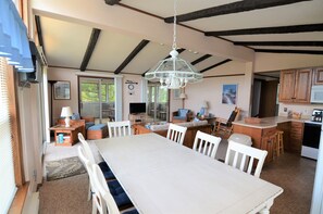 A spacious kitchen with a large dining table, wooden cabinets, and a hanging light fixture. - "OLD SCHOOL" REHOBOTH HOME IN NORTH SHORES - 3 FARVIEW (Rehoboth Beach)