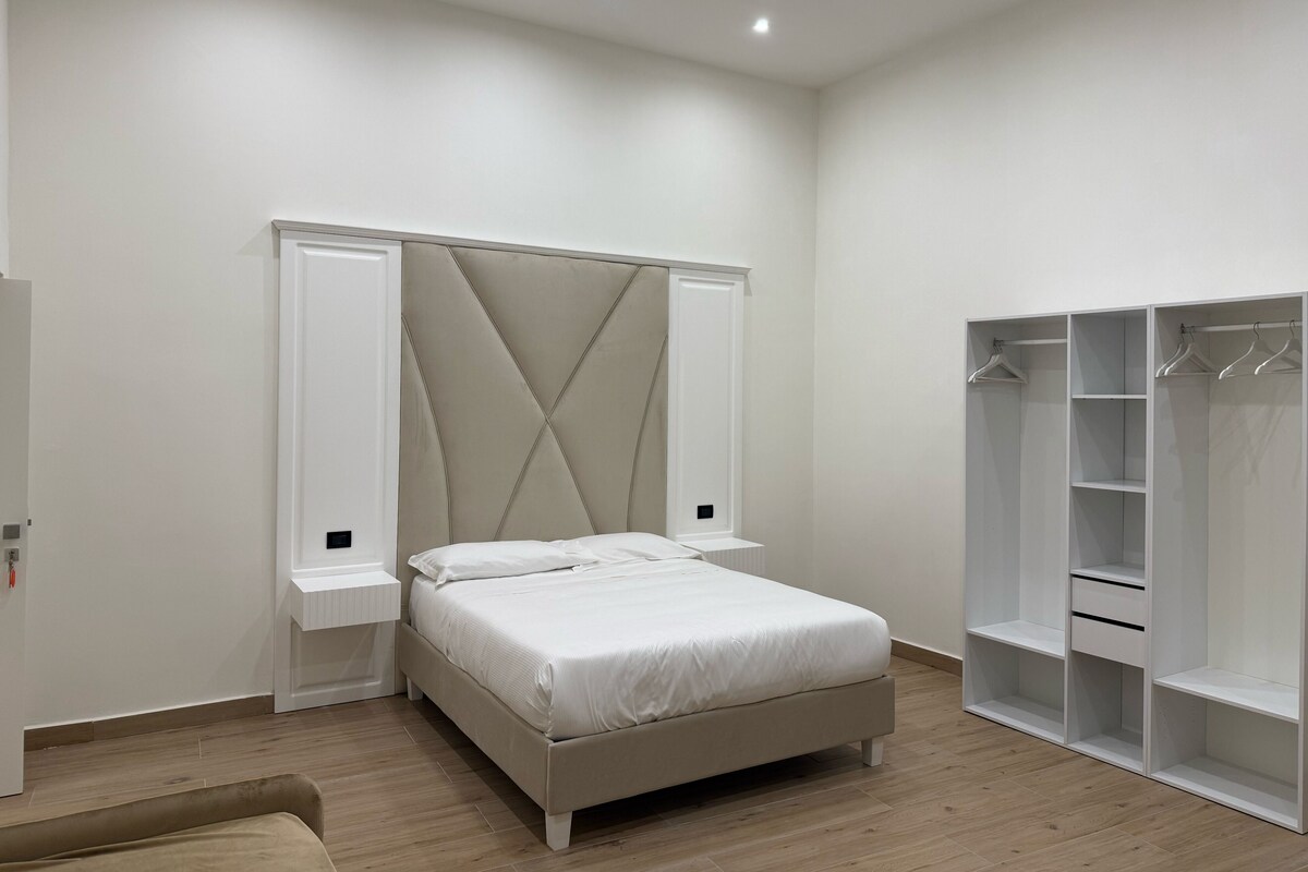 A bedroom with a bed, bedside tables, a wardrobe, and a closet.