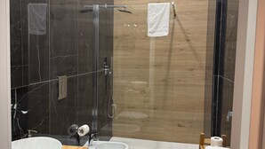A modern bathroom with a glass-enclosed shower, a wooden vanity with a large sink, and a toilet. - Chiaia Lifestyle (Naples)