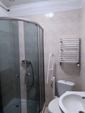 A bathroom with a glass-enclosed shower, a white sink, and a toilet. - DW Belmara (Kołobrzeg)