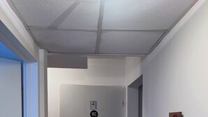 Ein Flur mit WC-Schild, einer Tür und einem Bild an der Wand.