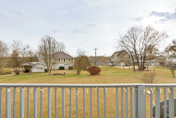 A residential area with houses, a grassy lawn, and a wooden fence. - Near Tennessee River! Pet-friendly Family Cottage! (Savannah)
