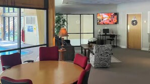 A conference room with a round table, red and black chairs, a television, and a plant. - Ski-in/ski-out Camelback Mtn Retreat w/ Hot Tub (Tannersville)