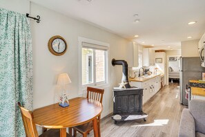 Una cocina acogedora con una mesa de madera, estufa y refrigerador.
