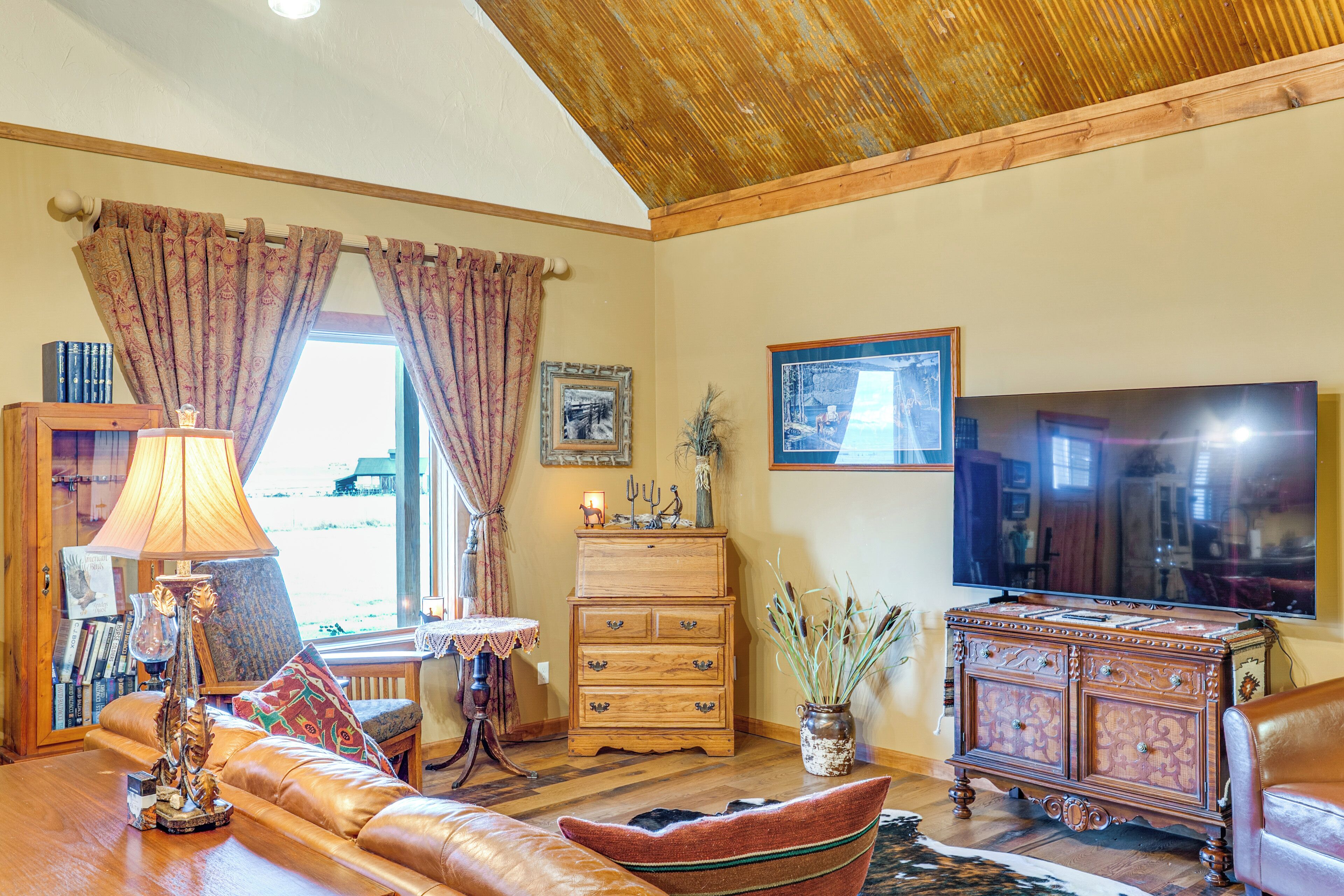 A cozy living room with a sofa, a wooden cabinet, a television, and a lamp.