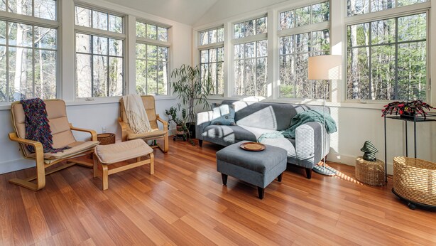 A spacious living room with large windows, a sofa, a chair, and a small table. - 1 Mi to Maine Street! Mcm-style Home in Brunswick (Brunswick)