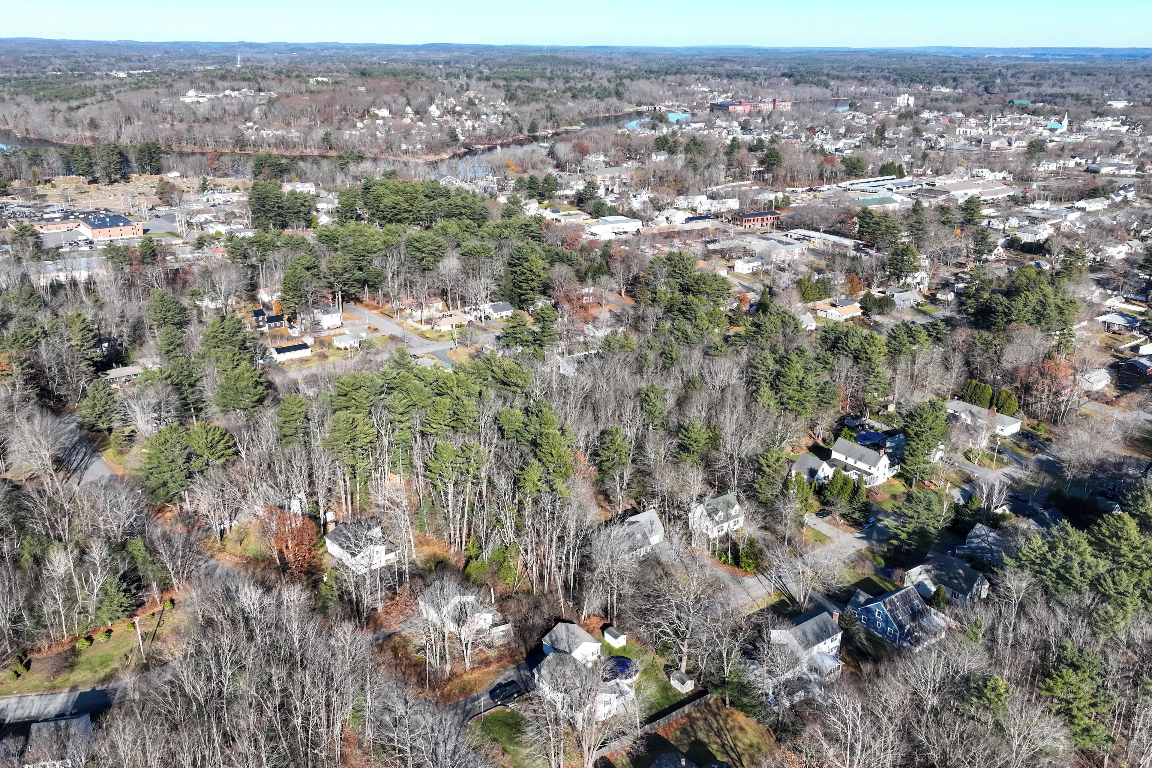An aerial view of a residential area with houses surrounded by trees.