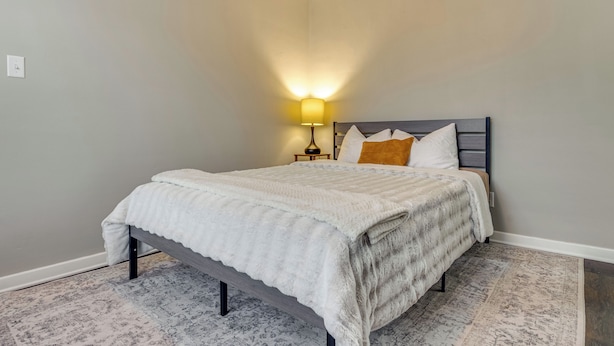 A bedroom with a bed, a nightstand, and a lamp. - Walk to Downtown Frankfort: Patio, Firepit & More! (Frankfort)