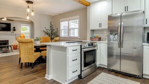 A modern kitchen with white cabinetry, a stainless steel refrigerator, and a built-in oven. - Walk to Downtown Frankfort: Patio, Firepit & More! (Frankfort)