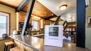 A kitchen with granite countertops, wooden cabinets, and a bar area.