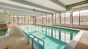 An indoor swimming pool with clear glass walls, a concrete floor, and a wooden ceiling. - 1 Mi to CU Boulder! Walkable Condo w/ Indoor Pool (Boulder)