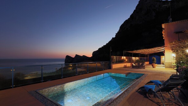 Ein Dachpool mit Blick auf das Meer im Abendlicht.