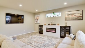 A modern living room with a fireplace, a large rug, and a flat-screen TV mounted on the wall. - Family Friendly! Newly Built North Vancouver Home! (Vancouver)