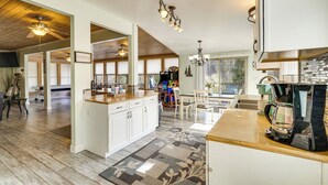 Une cuisine spacieuse dotée d’un grand îlot central, d’un plafond en bois et d’un éclairage moderne.