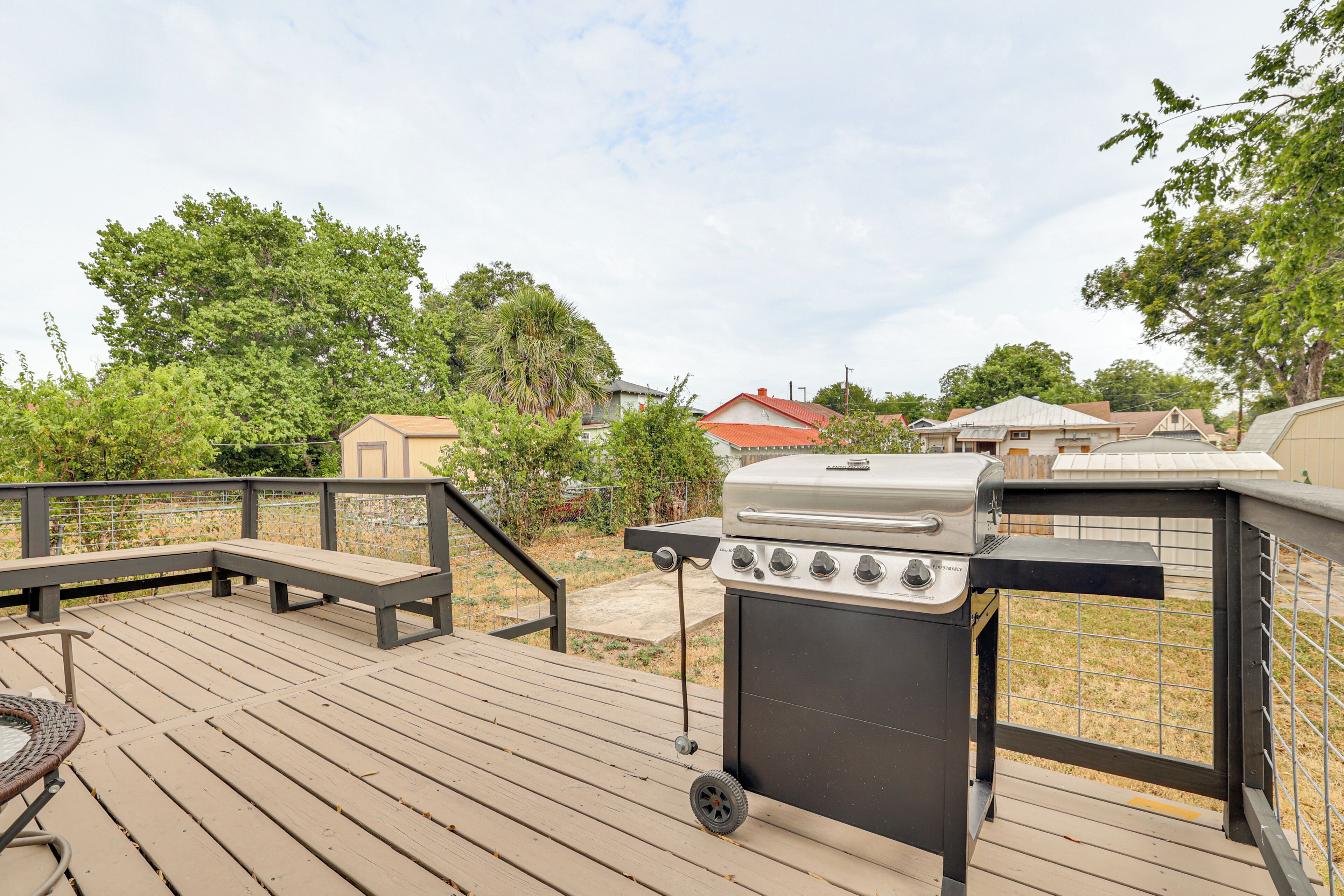 Una terraza de madera con una parrilla y zona de estar.