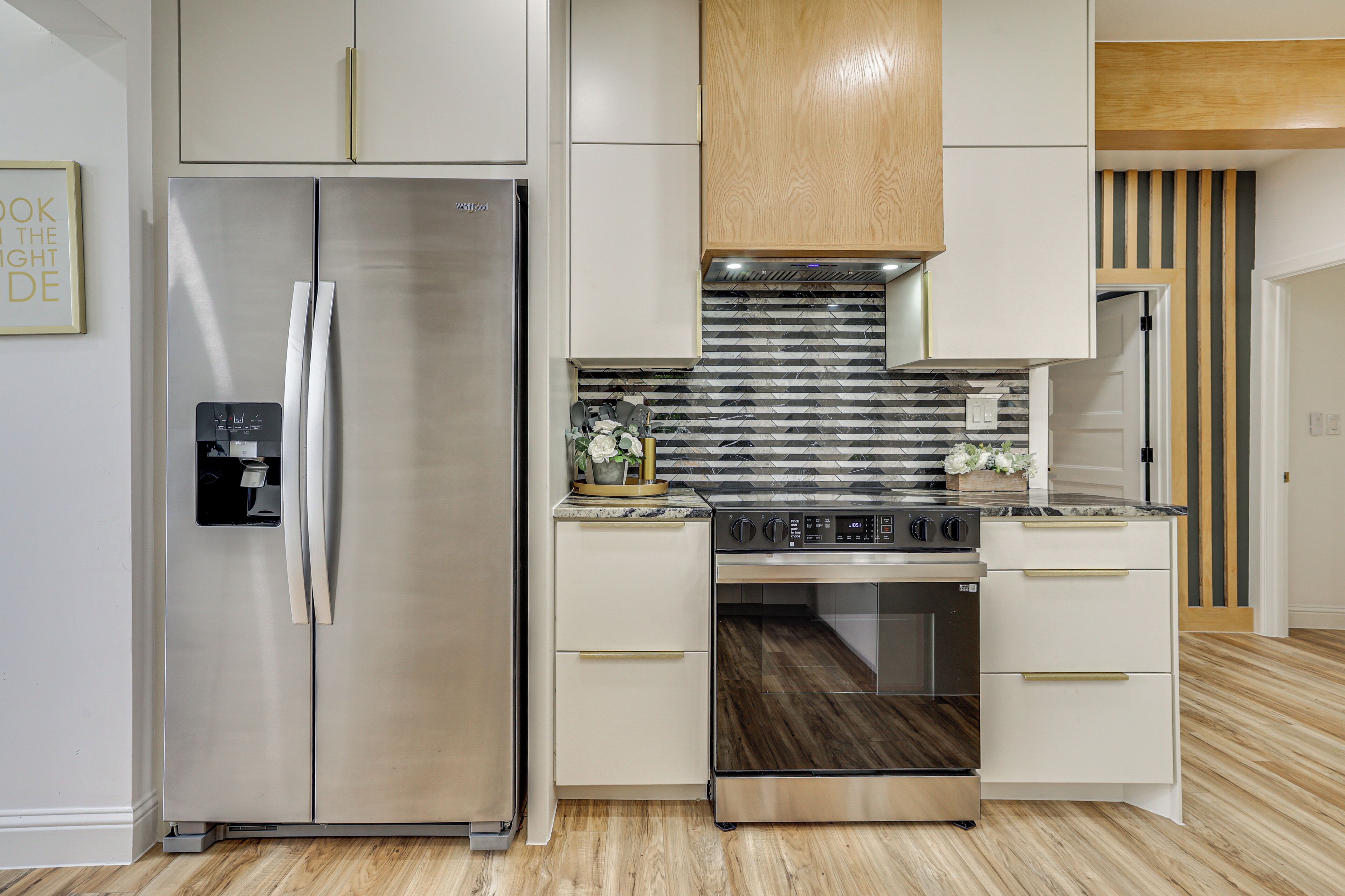 Una cocina moderna con electrodomésticos de acero inoxidable, armarios de madera y un salpicadero con diseño.