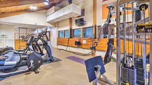A gym with various exercise equipment, including treadmills and weight machines, and a wooden reception desk. - Brand New Scandinavian Cabin 5 Mi to Main St Breck (Breckenridge)