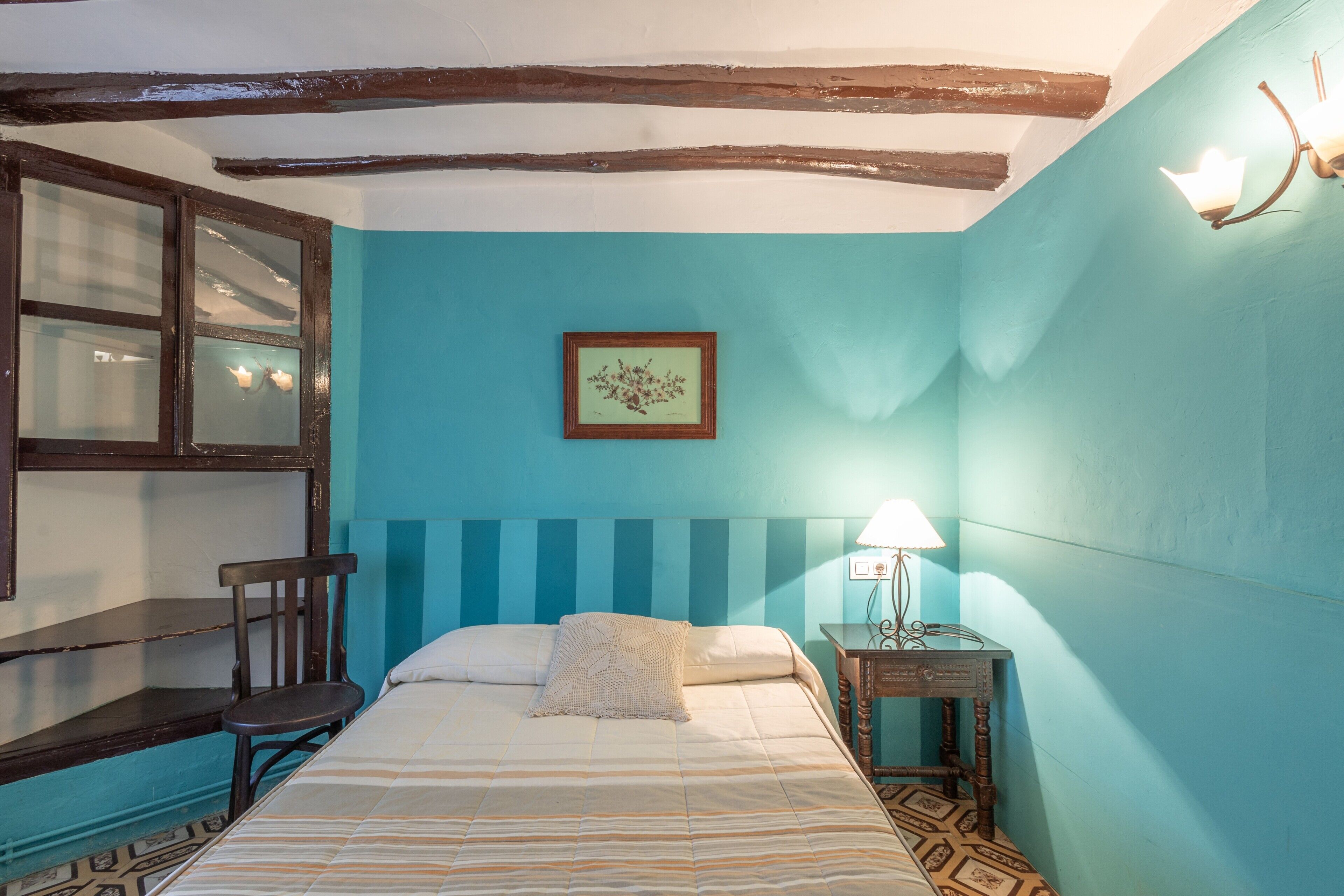 A room with a bed, a desk, and a chair.