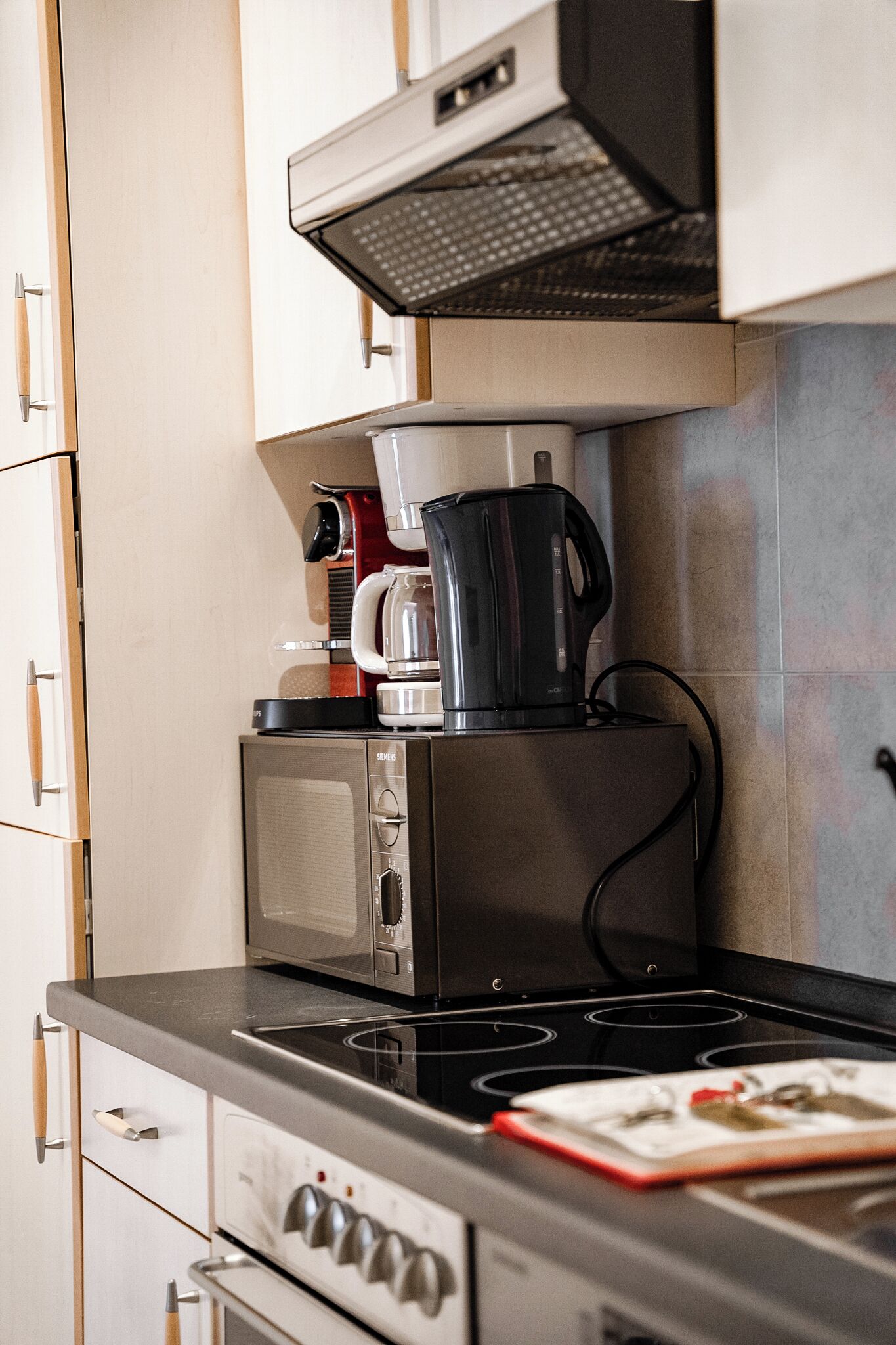 A kitchen with a microwave, coffee maker, and stove.