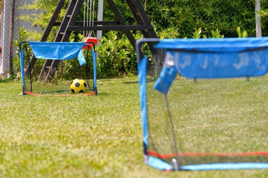Un but de football avec un ballon jaune sur l’herbe.