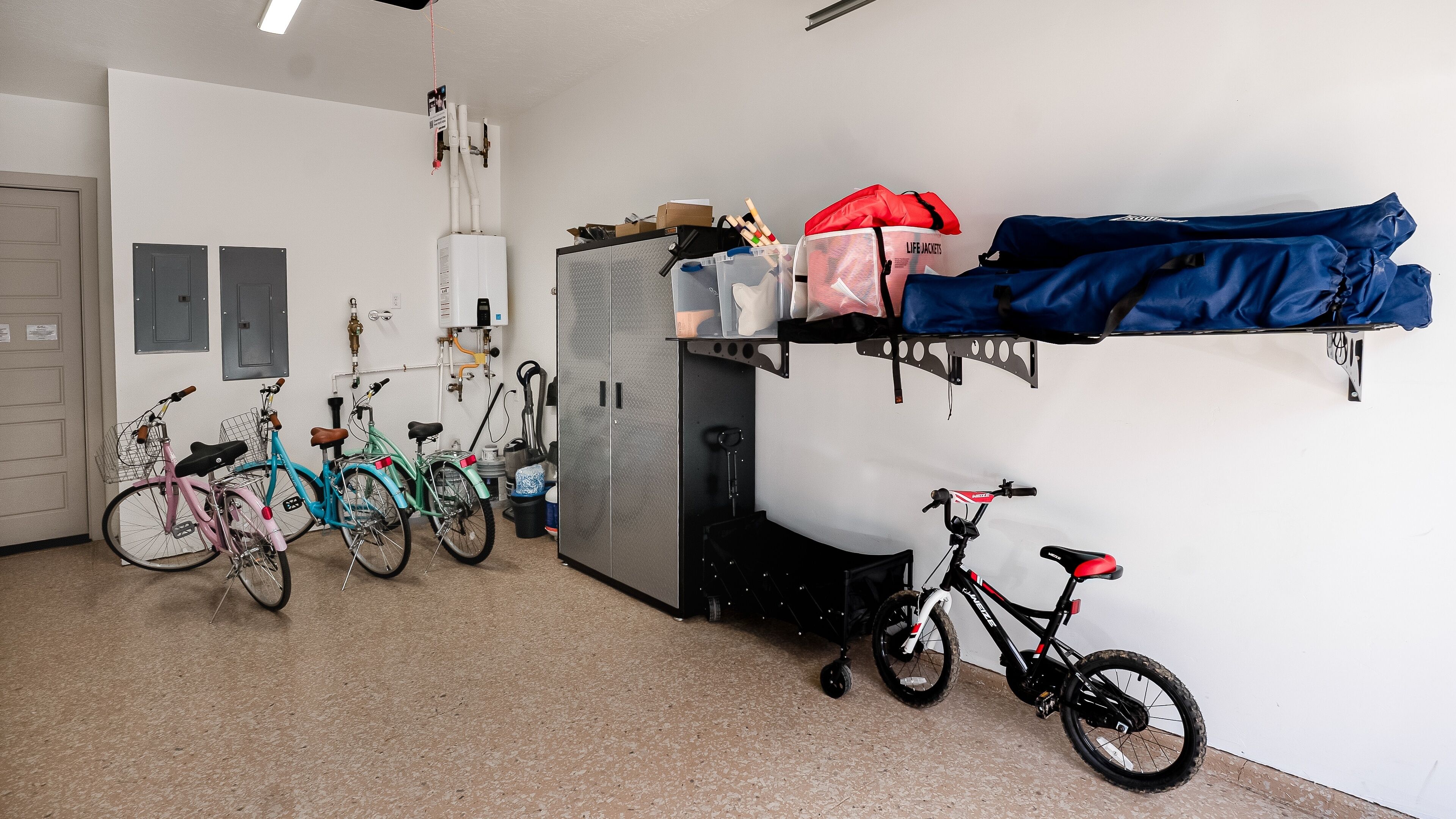 A room with bicycles, a water heater, and storage shelves.