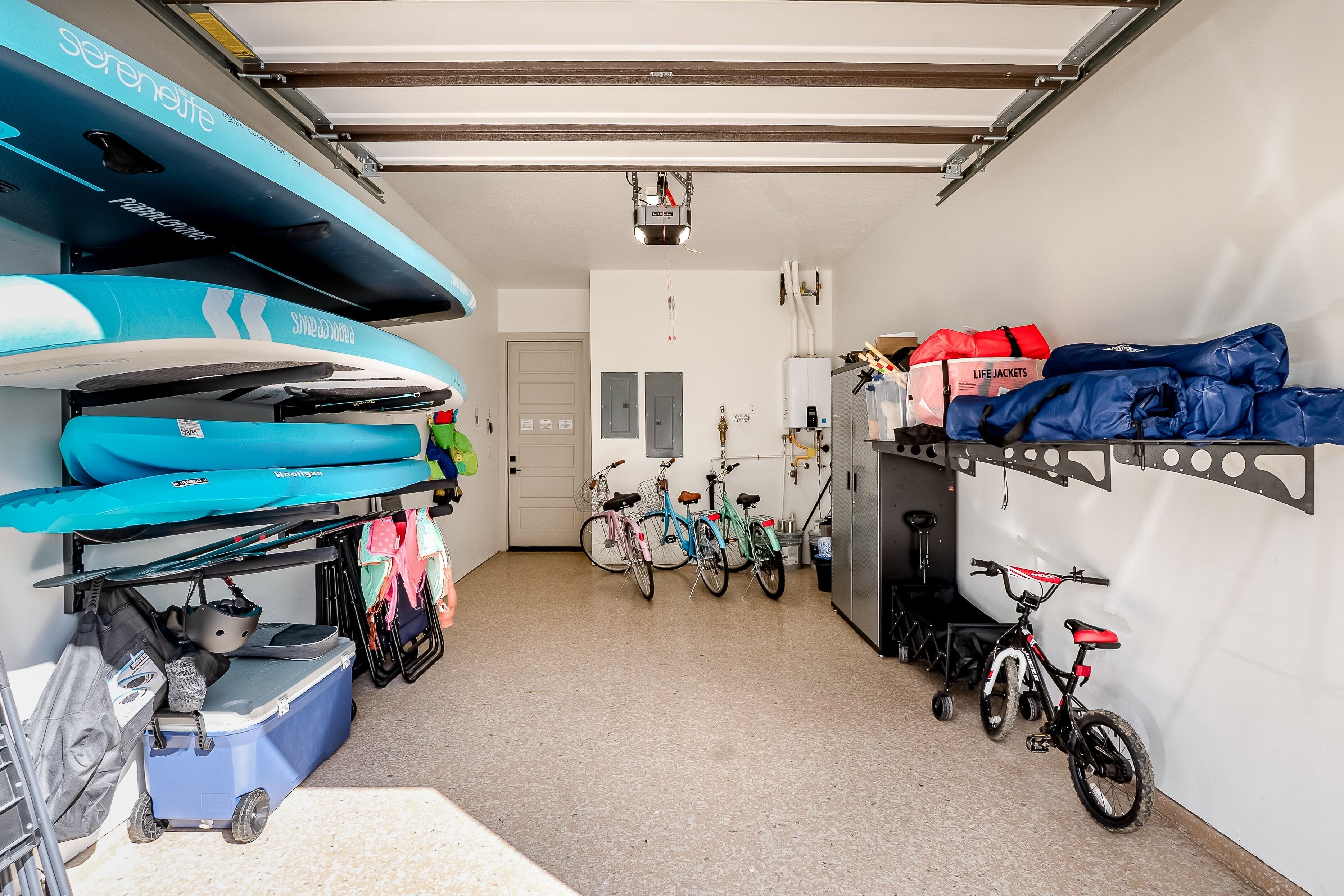 Eine Garage mit Kajaks, Fahrrädern und einer Tasche für Rettungswesten.