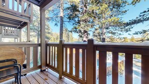 A wooden deck with a railing, a table, and chairs. - Western Slopes Villas #7 1 Bedroom Condo (Mammoth Lakes)