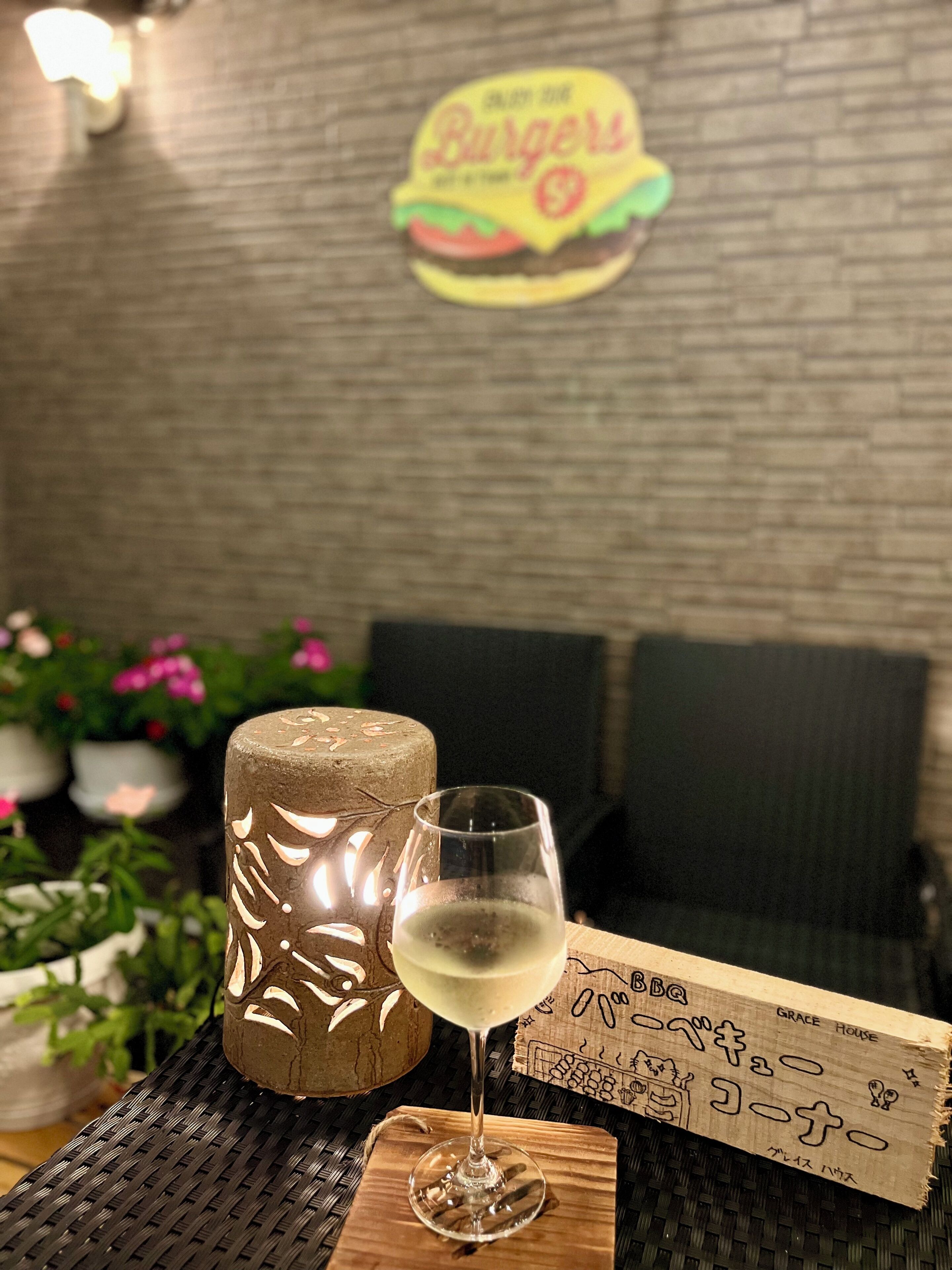 Uma mesa com uma taça de vinho branco, uma vela decorativa e um menu sobre um descanso tecido.