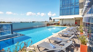 A rooftop pool with lounge chairs and a view of the city skyline. - MCollection - Mactan Island Stay Near Beach and Airport (Lapu-Lapu)
