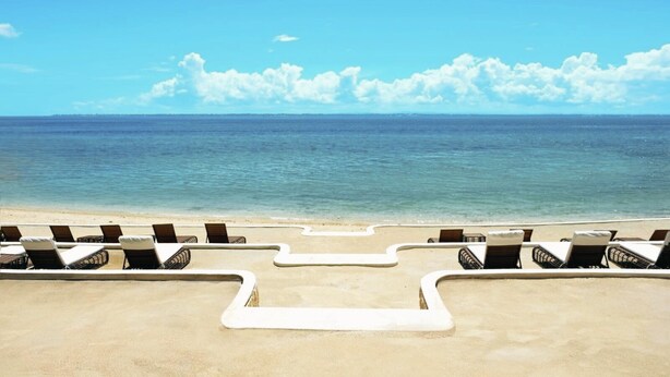 A beach with lounge chairs arranged in a semi-circle, facing the ocean. - MCollection - Mactan Island Stay Near Beach and Airport (Lapu-Lapu)