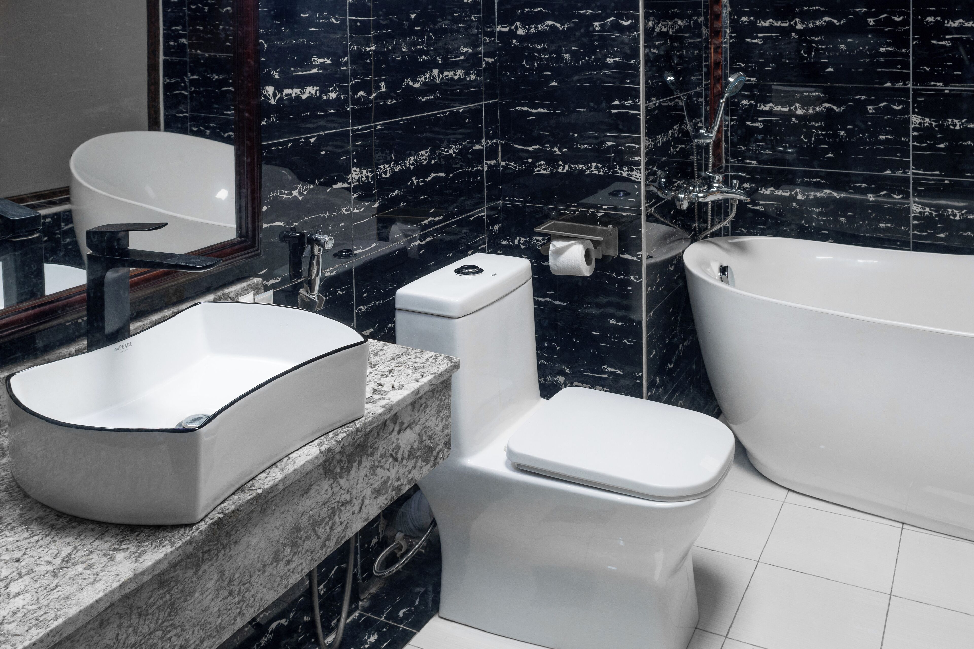 Une salle de bain moderne avec une baignoire sur pieds, un lavabo posé et des toilettes.