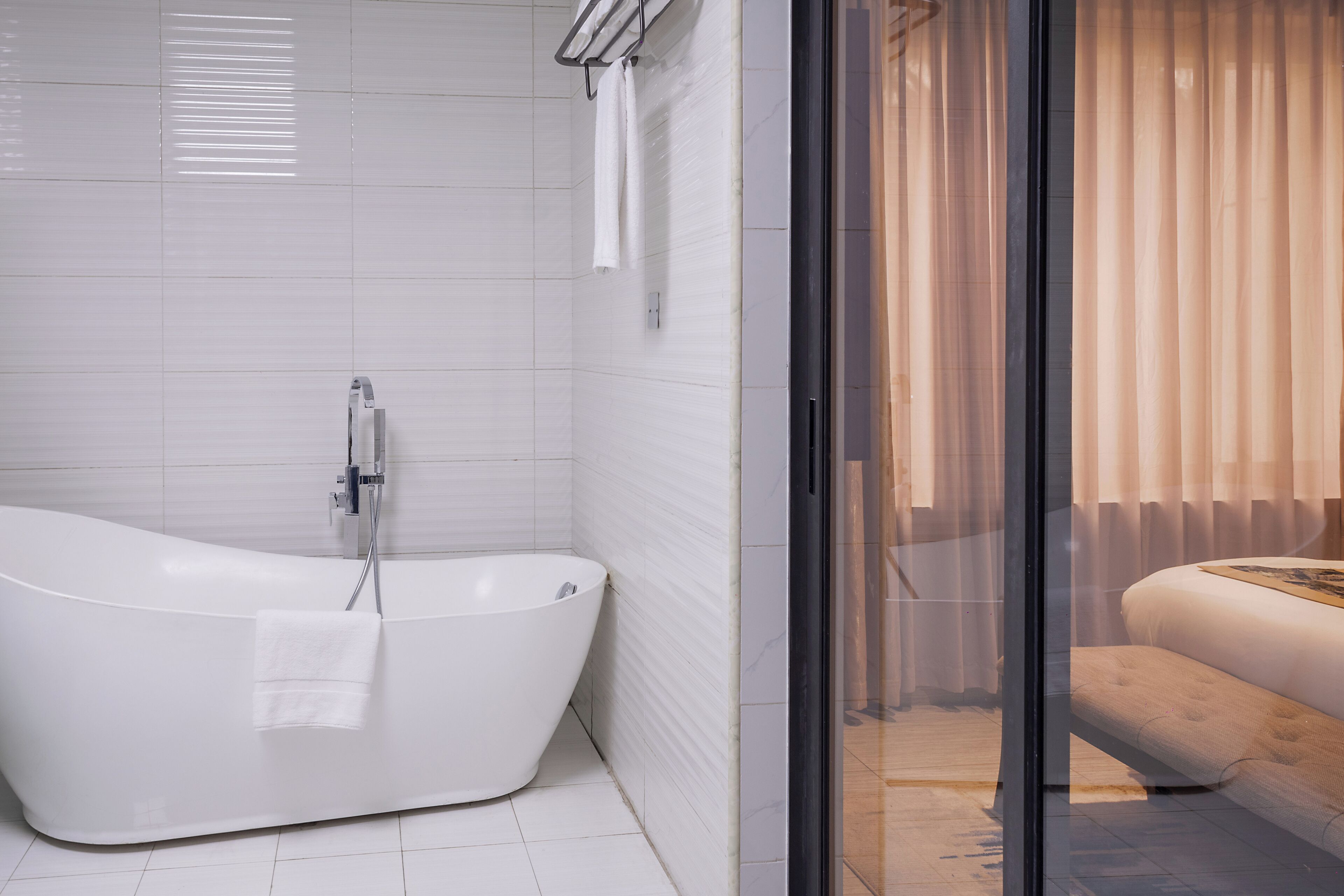 A modern bathroom with a freestanding bathtub, a glass shower enclosure, and a visible toilet.