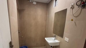 Ein kleines, kompaktes Badezimmer mit Toilette, Waschbecken und Dusche.