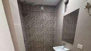 Ein kleines Badezimmer mit Toilette, Waschbecken und Dusche.