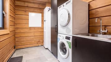 A compact laundry area with a washing machine, dryer, and sink.