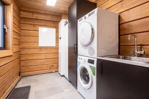 A compact laundry area with a washing machine, dryer, and sink. - Idre Luxury Chalet Winter Haven /w Sauna (Idre)