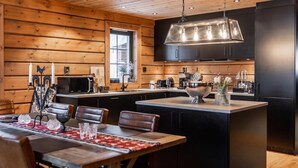 A modern kitchen with wooden paneling, a central island, and black cabinetry.