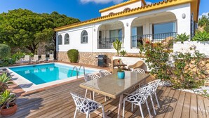 A villa with a swimming pool, outdoor seating, and a stone wall. - Private Villa with Sea Views in Torreblanca, Fuengirola (Fuengirola)