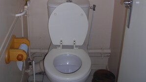 Une petite salle de bain comprenant des toilettes, un bidet en bois et un petit tabouret.