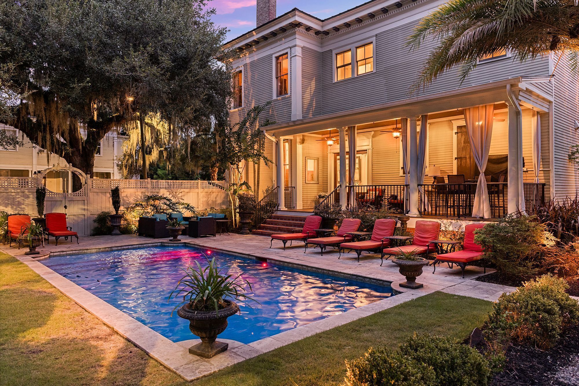 A poolside area with a pool, outdoor seating, and a covered patio.