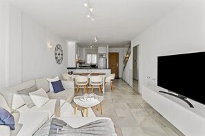 Ein modernes Wohnzimmer mit einer Couch, einem Couchtisch und einem Fernseher.