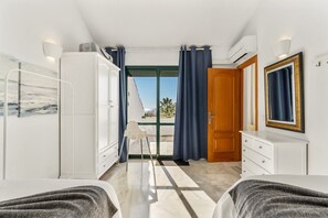 Ein Hotelzimmer mit Bett, Schreibtisch, Stuhl, Kleiderschrank und Blick ins Freie.